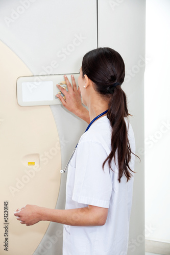 Photo: Female Doctor Operating CT Scan Machine Female Doctor Operating CT Scan Machine