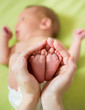 mother hands holding small baby's feet