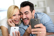 Cheerful couple having fun using smartphone