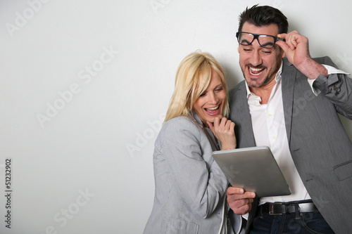 Photo: Trendy couple websurfing on digital tablet Trendy couple websurfing on digital tablet