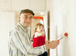 Man with child paints wall