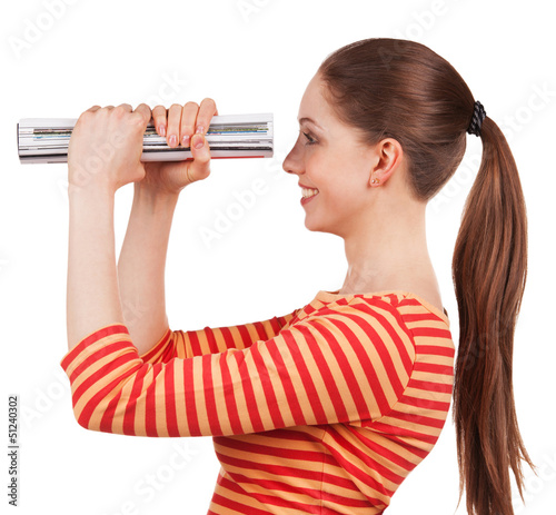 Photo: Girl looks in the magazine folded, like a telescope Girl looks in the magazine folded, like a telescope