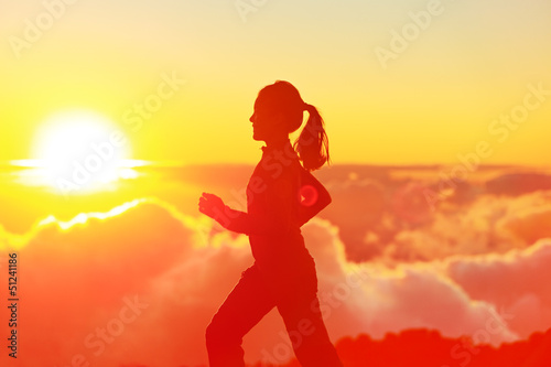 Photo: Runner woman running in sunshine sunset Runner woman running in sunshine sunset