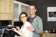 Photo: Happy Caucasian couple in front ov the oven Happy Caucasian couple in front ov the oven