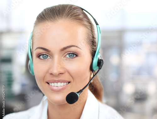 Photo: Female customer support operator with headset and smiling Female customer support operator with headset and smiling
