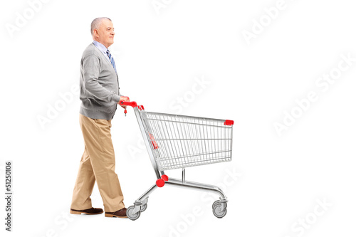 Photo: Full length potrait of a gentleman walking and pushing an empty Full length potrait of a gentleman walking and pushing an empty