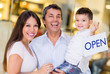 Family holding an open sign