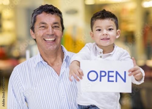 Photo: Dad and son holding an open sign Dad and son holding an open sign