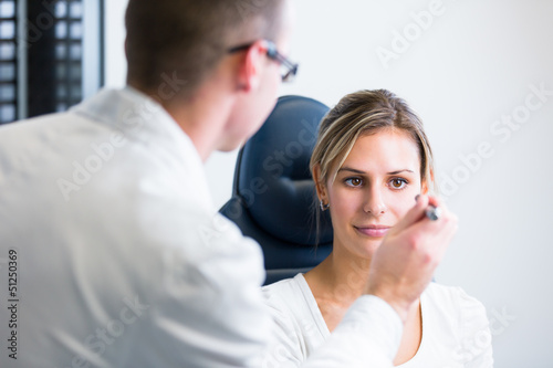 Photo: Optometry concept - pretty young woman having her eyes examined Optometry concept - pretty young woman having her eyes examined