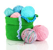 Colorful yarn for knitting in green basket isolated on white