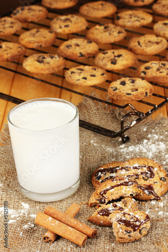 Photo: Chocolate cookies on the baking with glass of milk close up Chocolate cookies on the baking with glass of milk close up