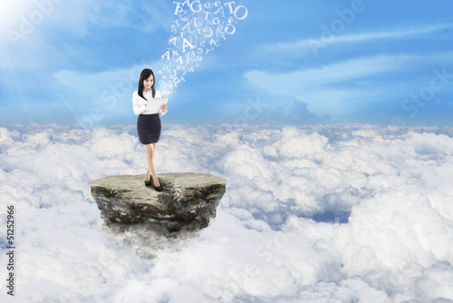 Photo: Businesswoman send message on clouds Businesswoman send message on clouds