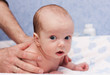massage newborn baby lying on his stomach