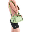 A young woman carrying a green canvas handbag