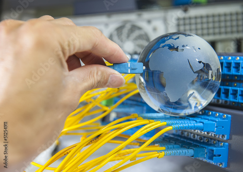 Photo: globe with network cables and servers in a technology data cente globe with network cables and servers in a technology data cente