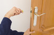 Carpenter fixing a lock in the door  with a screwdriver