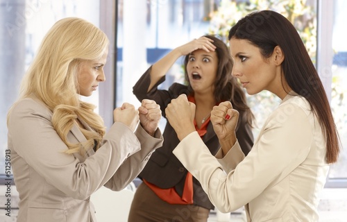 Photo: Determined businesswomen fighting at workplace Determined businesswomen fighting at workplace
