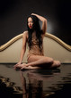 Girl with wet clothes sitting in the black water 