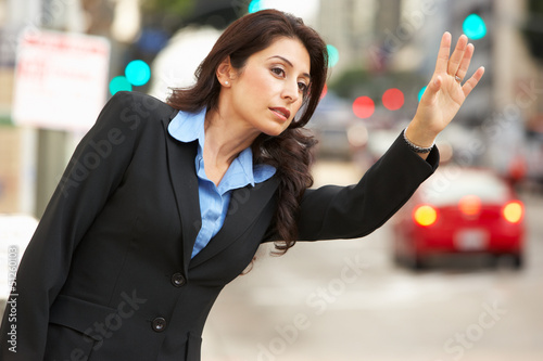 Photo: Businesswoman Hailing Taxi In Busy Street Businesswoman Hailing Taxi In Busy Street