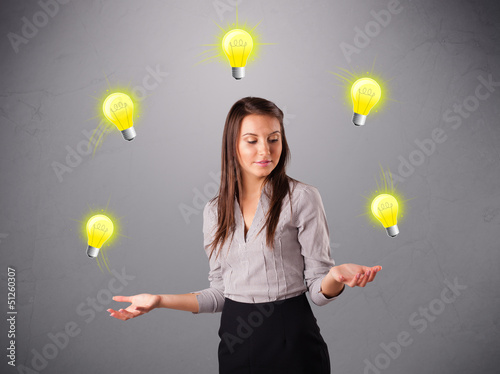 Photo: young lady standing and juggling with light bulbs young lady standing and juggling with light bulbs