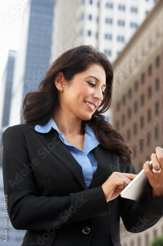Photo: Businesswoman Working On Tablet Computer Outside Office Businesswoman Working On Tablet Computer Outside Office
