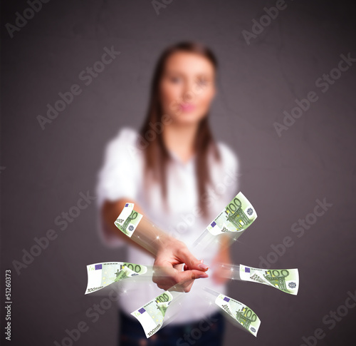 Photo: Pretty woman standing and throwing money Pretty woman standing and throwing money