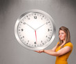Foto: Attractive lady holding a huge clock Attractive lady holding a huge clock