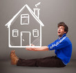 Young boy holding a huge drawn house