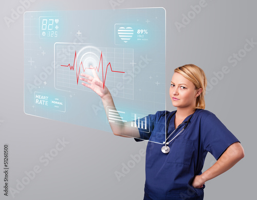 Photo: Young nurse pressing modern medical type of buttons Young nurse pressing modern medical type of buttons
