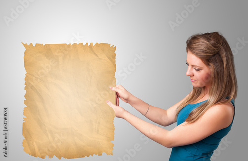 Photo: Young girl presenting old paper copy space Young girl presenting old paper copy space