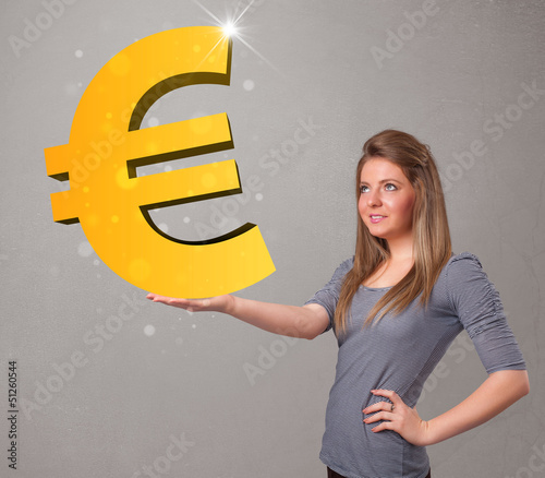 Photo: Beautiful girl holding a big 3d gold euro sign Beautiful girl holding a big 3d gold euro sign