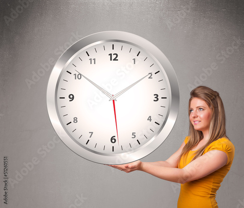Photo: Attractive lady holding a huge clock Attractive lady holding a huge clock