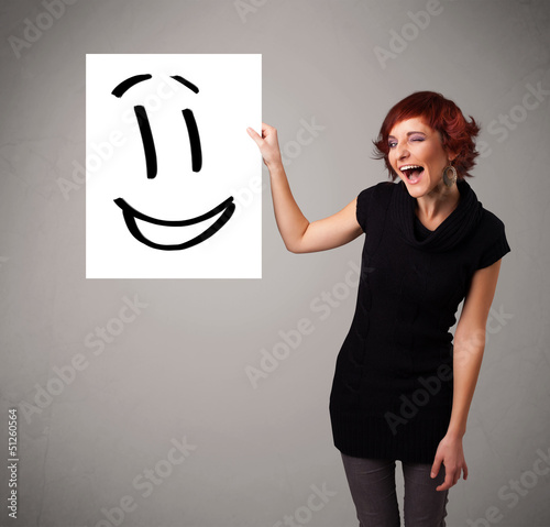 Photo: Young woman holding smiley face drawing Young woman holding smiley face drawing