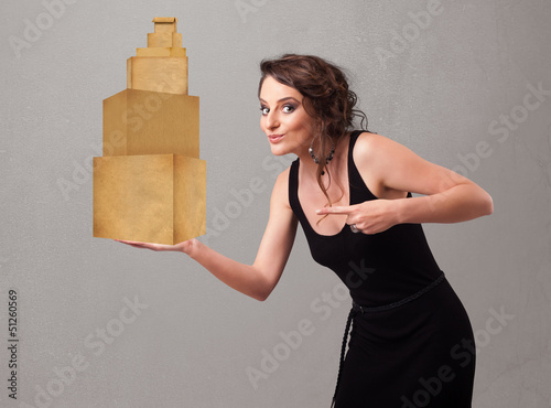 Photo: Young lady holding a set of brown cardboard boxes Young lady holding a set of brown cardboard boxes