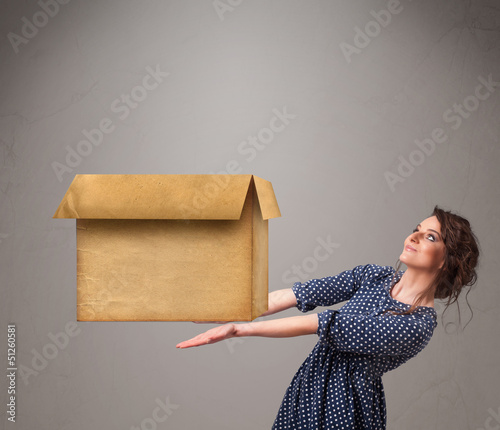 Photo: Young woman holding an empty cardboard box Young woman holding an empty cardboard box