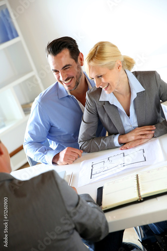 Photo: Couple meeting real-estate agent to buy property Couple meeting real-estate agent to buy property