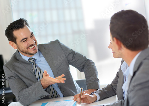 Photo: Businessman presenting contract to partners Businessman presenting contract to partners