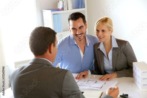 Photo: Couple meeting real-estate agent to buy property Couple meeting real-estate agent to buy property