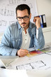 Architect working in office on blueprint
