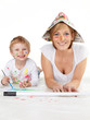 Cute boy and his mother painting with water colours