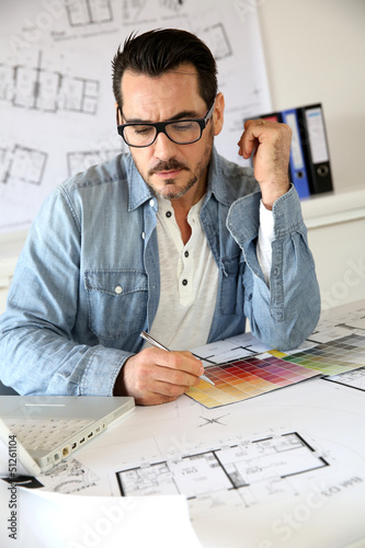Photo: Architect working in office on blueprint Architect working in office on blueprint