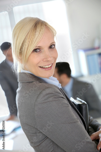 Photo: Businesswoman portrait with group in background Businesswoman portrait with group in background