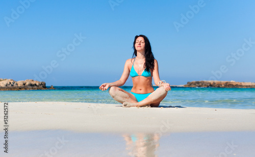 Photo: woman meditating on the beach woman meditating on the beach