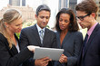 Foto: Businessmen And Businesswomen Using Digital Tablet Outside Businessmen And Businesswomen Using Digital Tablet Outside