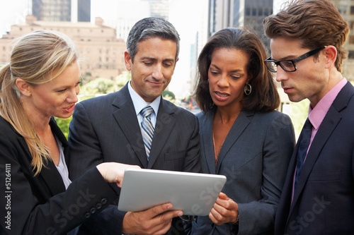 Photo: Businessmen And Businesswomen Using Digital Tablet Outside Businessmen And Businesswomen Using Digital Tablet Outside