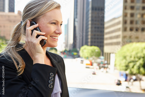 Photo: Businesswoman Outside Office On Mobile Phone Businesswoman Outside Office On Mobile Phone
