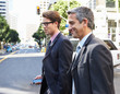 Photo: Two Businessman Chatting Whilst Crossing Street Two Businessman Chatting Whilst Crossing Street