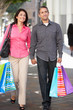 Photo: Couple Carrying Shopping Bags On City Street Couple Carrying Shopping Bags On City Street