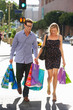 Couple Carrying Shopping Bags On City Street