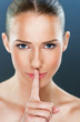 Beautiful woman showing a silence gesture ,close up